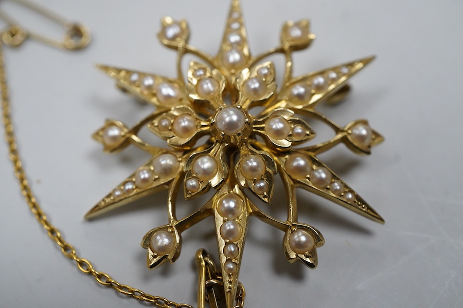 An Edwardian seed pearl brooch, early 20th century, designed as a snowflake, set with split seed pearls, mounted in gold, length 3.7cm, stamped 15CT, pearls untested, Condition: good, minor wear